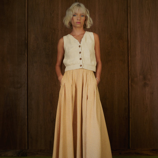 Front view of the Alli Marye Rosemary Skirt in CandyCorn gingham, styled with a cream knit vest.