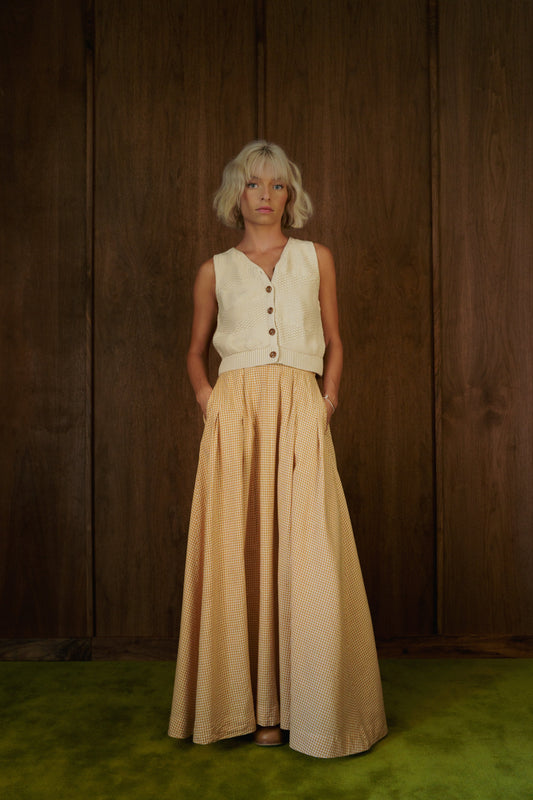 Front view of the Alli Marye Rosemary Skirt in CandyCorn gingham, styled with a cream knit vest.